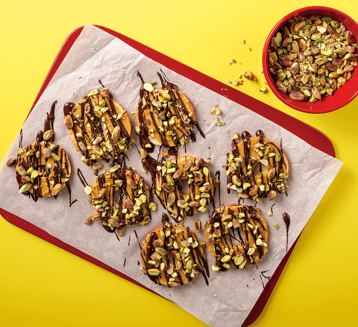 chocolate and peanut butter covered apple slices with pistachios